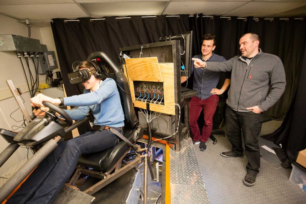 The three researchers test the autonomous vehicle simulator.