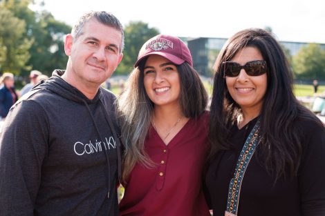 Parents pose for a photo with their student during Family Weekend.