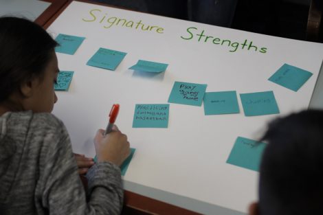 A student writes on a Post-It note