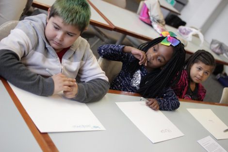 School children use magic markers during the session led by Lafayette College students in the Happiness First-Year Seminar.