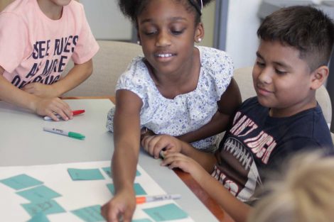 School children write on Post-It Notes during the class section led by Lafayette's Happiness First-Year Seminar.