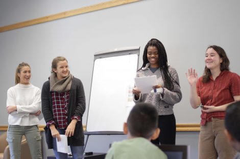 Students explain the rules to mad libs to a group of elementary students.
