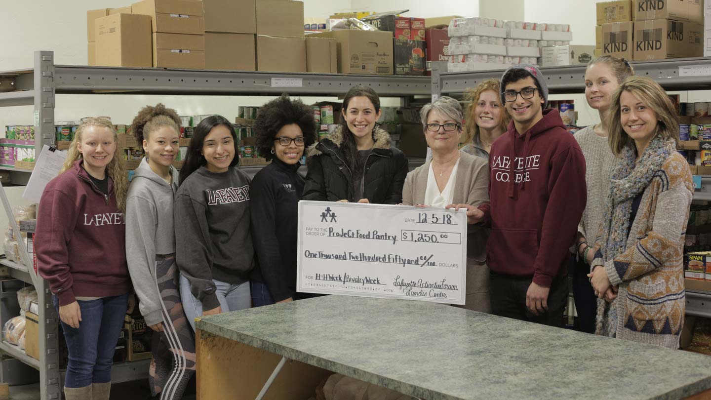 A group photo with an oversized $1,250 check for ProJeCt Food Pantry