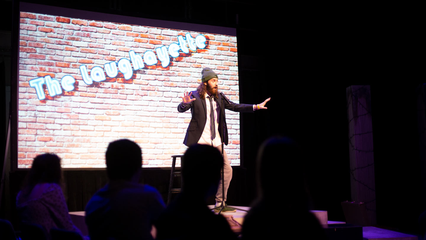 A student performs standup comedy in front of other Lafayette College students in Buck Hall.