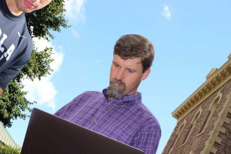 Professor looks at his laptop during the Center for Community Engagement program.