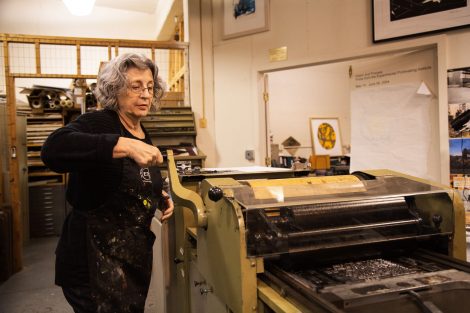 MaryAnn Miller works on the printmaking press at Lafayette College's Experimental Printmaking Institute.