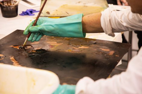 Sam Messer paints on a print at Lafayette College's Experimental Printmaking Institute