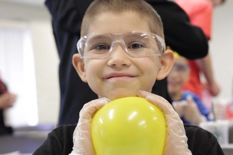 Student smiles with yellow balloon.
