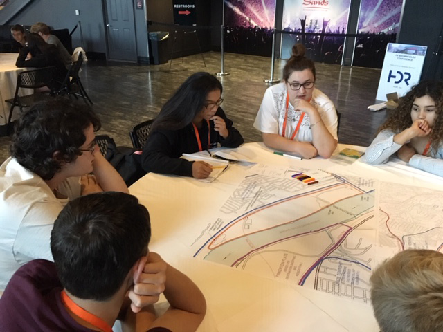 Students talk around a table at the brownfields conference.