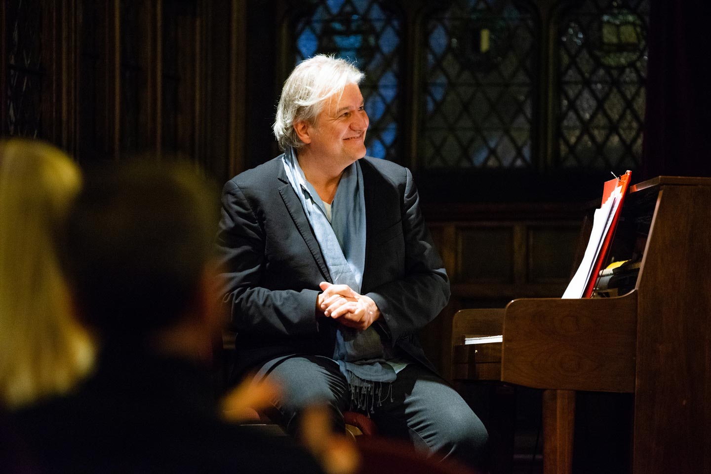Hans Ludemann smiles as he sits by the piano.