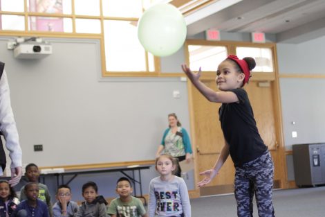 Elementary student demonstrates how easy it is to keep one balloon in the air.