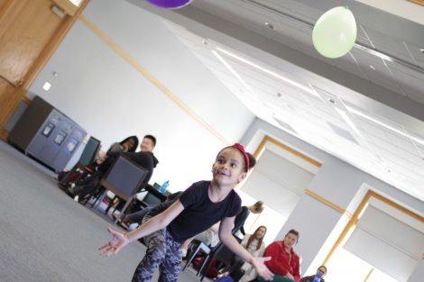 Elementary student realizes keeping two balloons in the air is harder.
