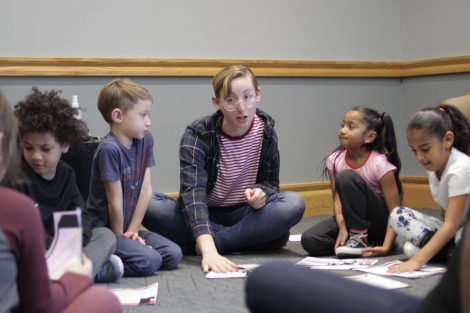 Lafayette student gathers elementary students around their colored pages.