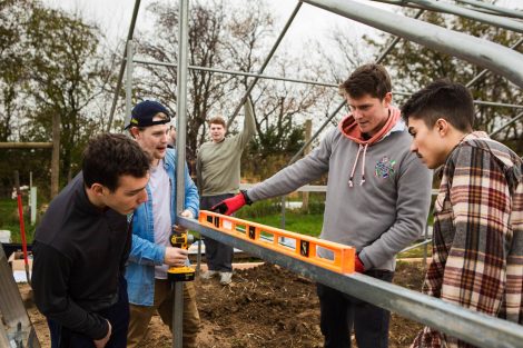 Members of Phi Psi fraternity help with the building of a hoop house, a 22-by-21-foot structure that will help LaFarm extend its growing season earlier in spring and later in fall.