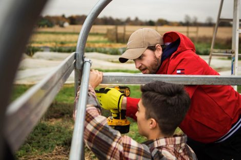 Members of Phi Psi fraternity help with the building of a hoop house, a 22-by-21-foot structure that will help LaFarm extend its growing season earlier in spring and later in fall.