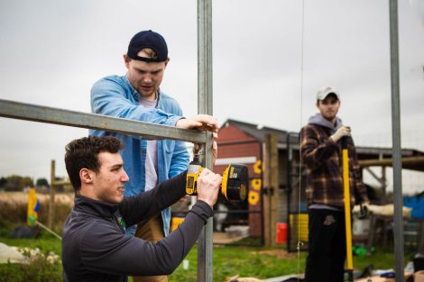 Members of Phi Psi fraternity help with the building of a hoop house, a 22-by-21-foot structure that will help LaFarm extend its growing season earlier in spring and later in fall.