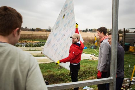 Members of Phi Psi fraternity help with the building of a hoop house, a 22-by-21-foot structure that will help LaFarm extend its growing season earlier in spring and later in fall.