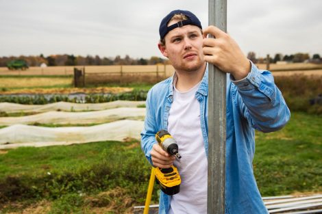 Members of Phi Psi fraternity help with the building of a hoop house, a 22-by-21-foot structure that will help LaFarm extend its growing season earlier in spring and later in fall.