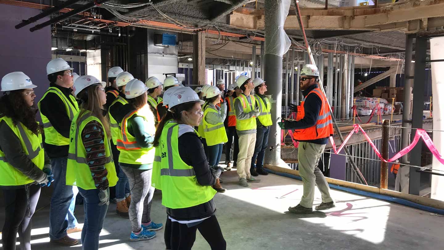 A construction worker gives Lafayette College students a tour of Rockwell Integrated Sciences Center.