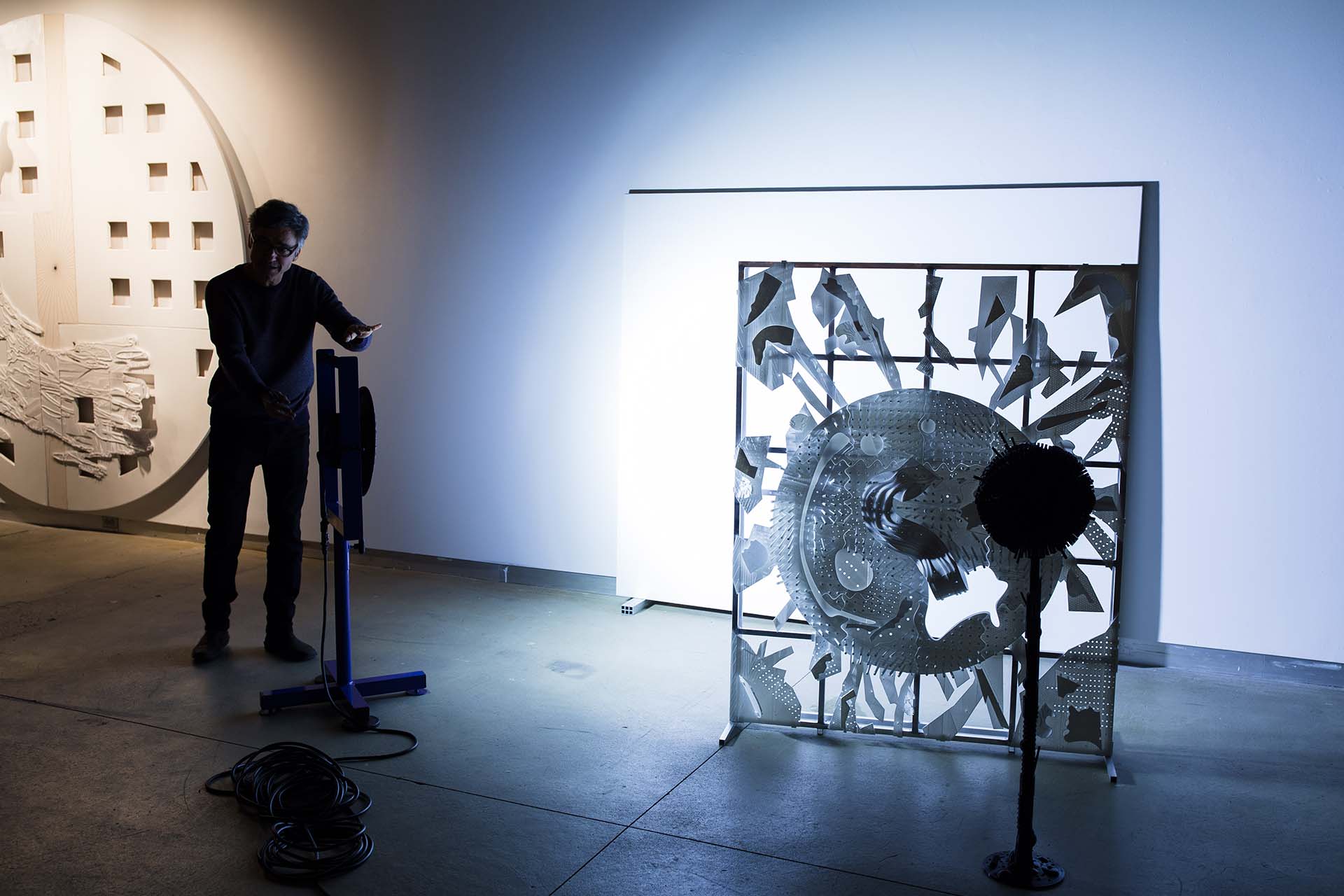 Pedro Barbeito moves between elements of a dimensional art work.
