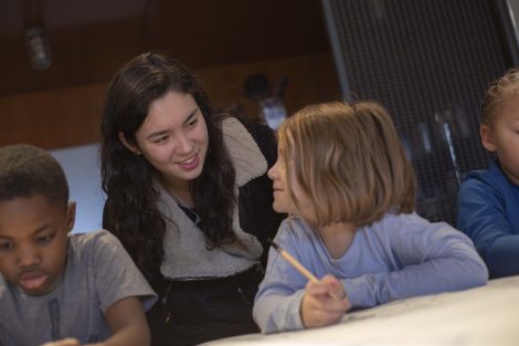 A Lafayette student helps a little girl with her pencil drawing.