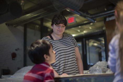 A Lafayette student watches as boys work with clay.
