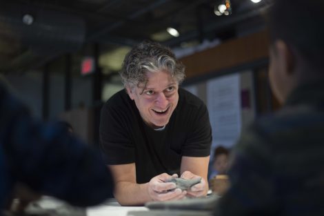 Nestor Gil smiles as he looks at one sculptor's work.