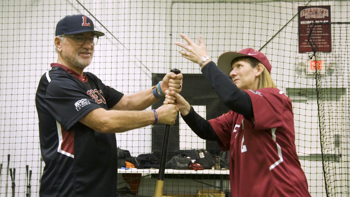 Chicago Cubs manager Joe Maddon '76 and Lafayette College President Alison Byerly see who can get their hand at the top of a baseball bat