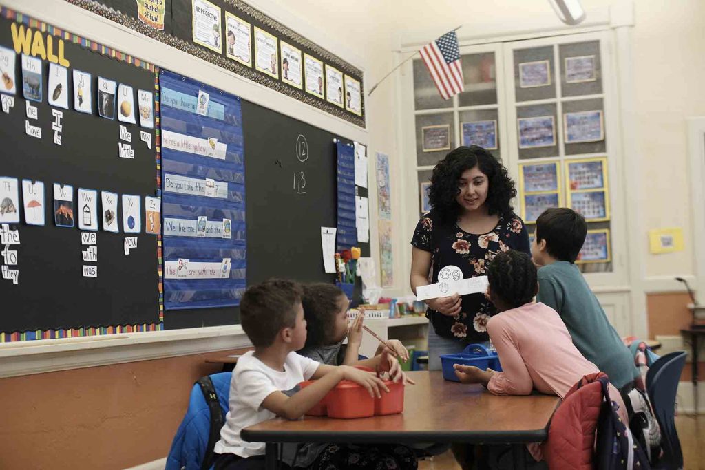 Lafayette student holds up crown and points to pictures on it that start with the letter G.