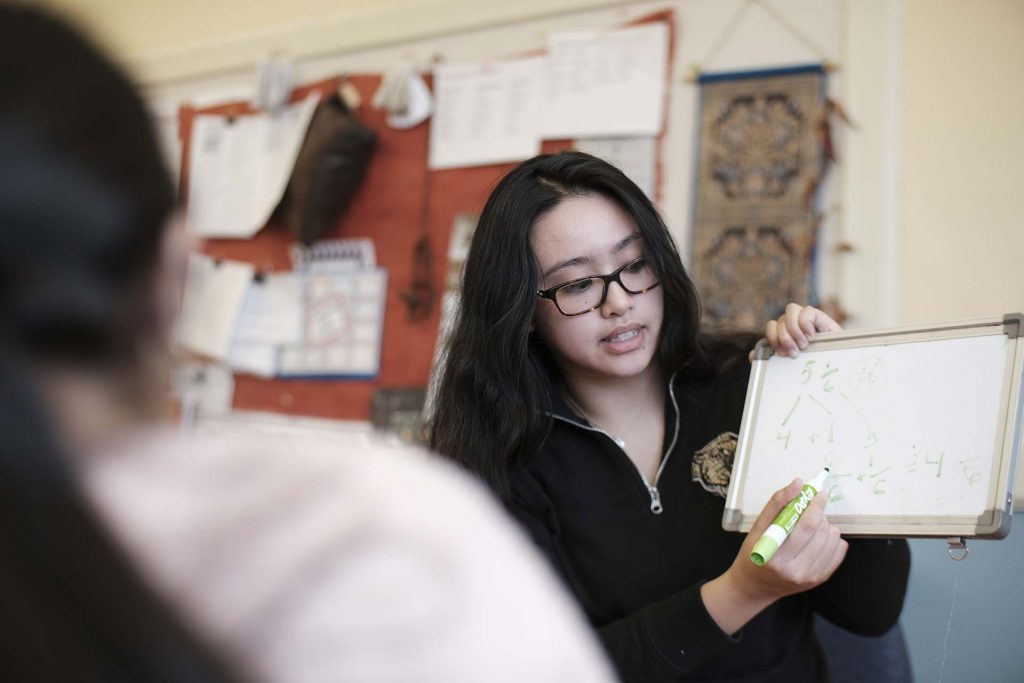 Lafayette student holds up a mini whiteboard and shows how to convert a fraction.
