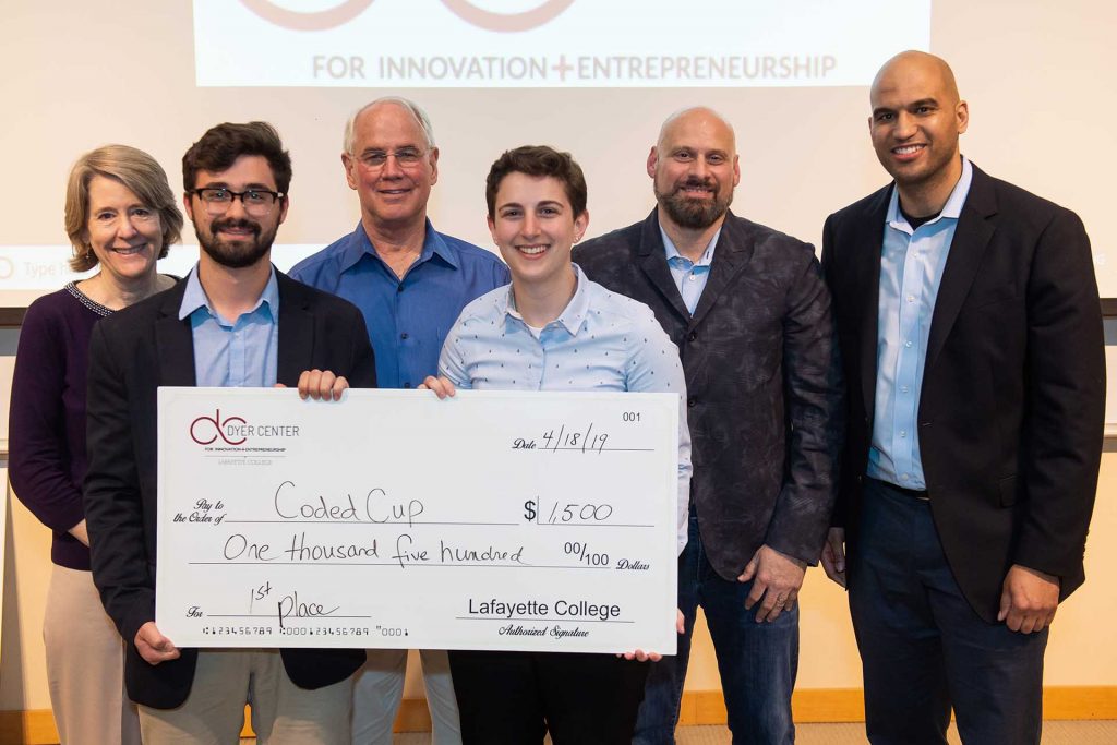 Student winners hold a check surrounded by judges and Dyer Center director.