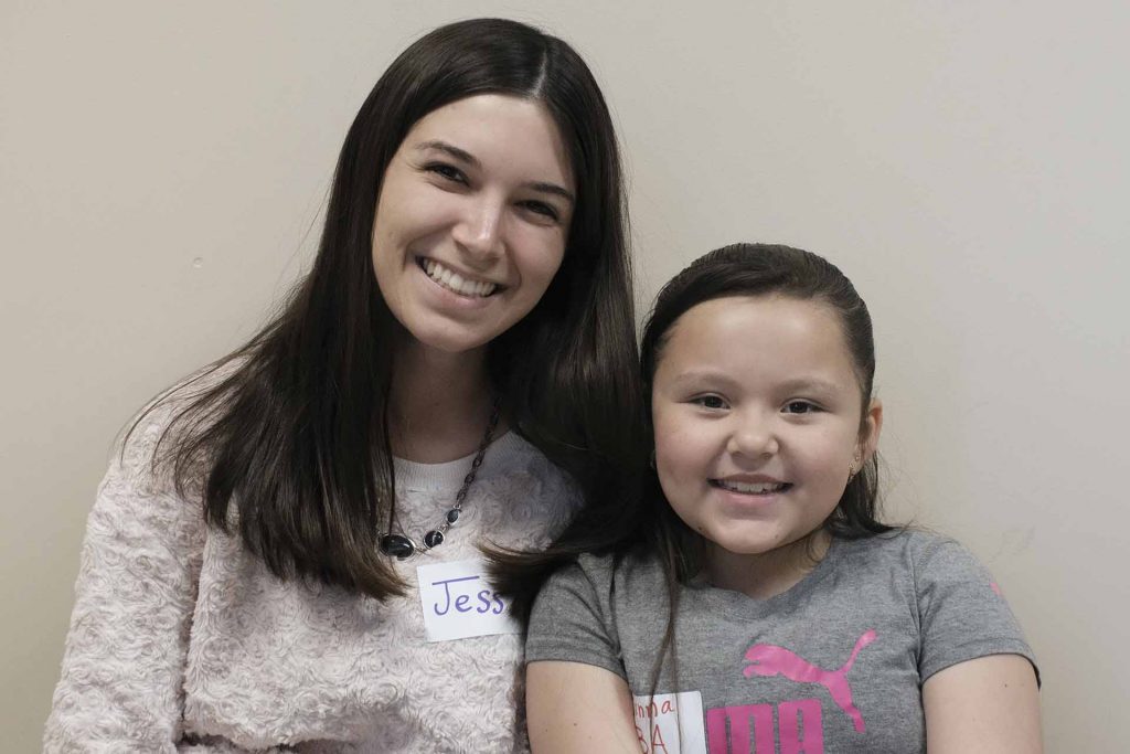 Illana sits next to her pen pal Jess