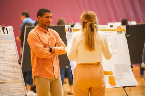 Students explain their research to visitors at the 2019 spring poster session in Kamine Gymnasium in Kirby Sports Center.