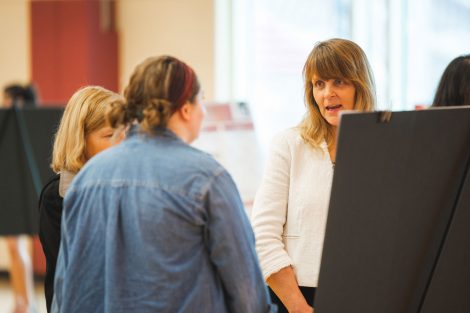 Students explain their research to visitors at the 2019 spring poster session in Kamine Gymnasium in Kirby Sports Center.