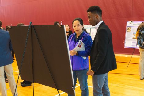 Students explain their research to visitors at the 2019 spring poster session in Kamine Gymnasium in Kirby Sports Center.