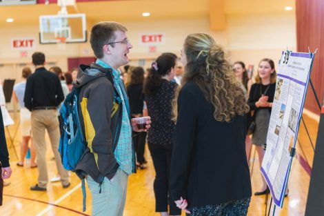 Students explain their research to visitors at the 2019 spring poster session in Kamine Gymnasium in Kirby Sports Center.