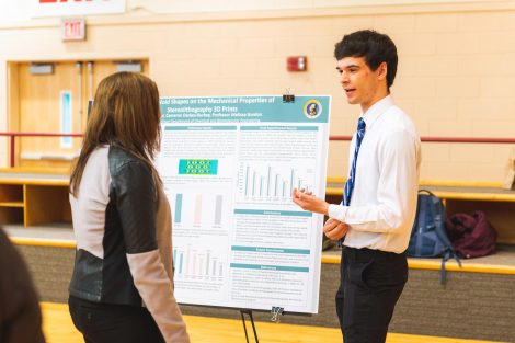 Students explain their research to visitors at the 2019 spring poster session in Kamine Gymnasium in Kirby Sports Center.