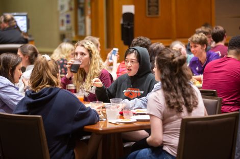 Students chow down on breakfast food late at night, served up by faculty and staff.