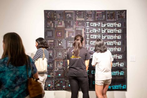 Two guests look at a quilt created by Chawne Kimber, professor of mathematics