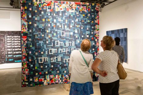 Two guests look at a quilt created by Chawne Kimber, professor of mathematics