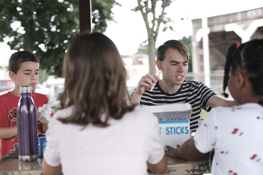 Lafayette student talks about a craft project while handing out supplies.