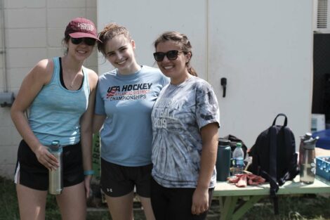 Three students pose for a photo at the urban garden