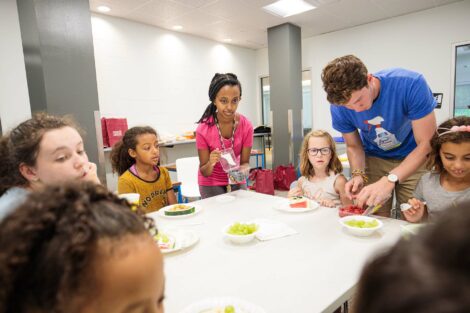 Students help kids in the community make a slice of watermelon pizza