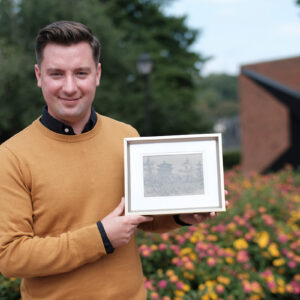 Eric Hupe holds a painting created by his mother.