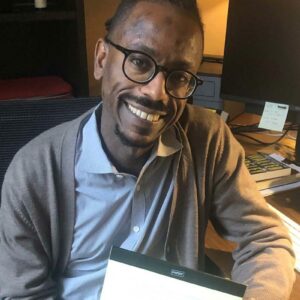 Mikael Awake holds the kind of yellow legal pad he uses for his writing.