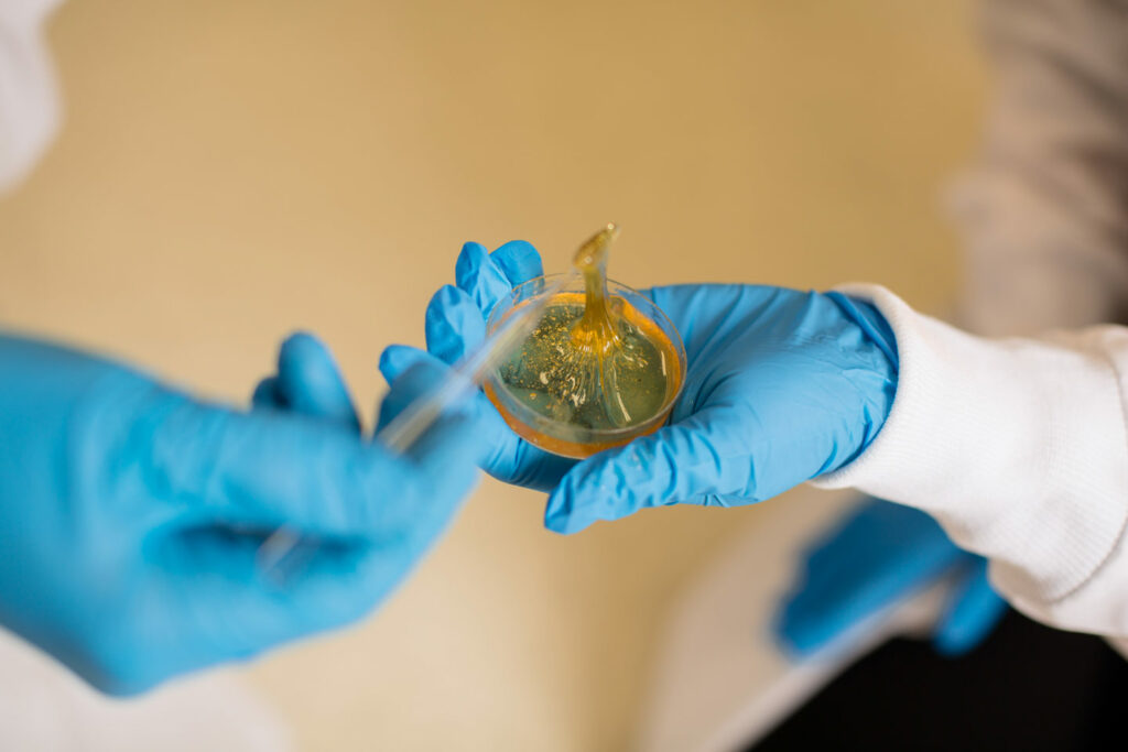 A polymer is worked with on a petri dish in the lab.