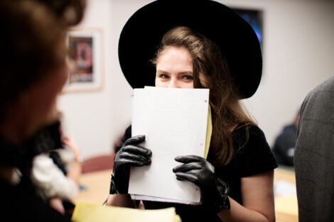 students prepare hair and makeup backstage