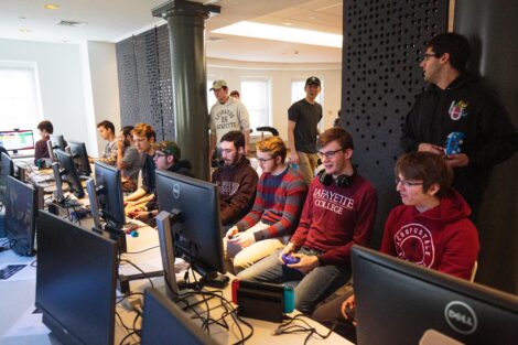 A group of students from Lafayette and Lehigh Esports clubs sit together and play video games.