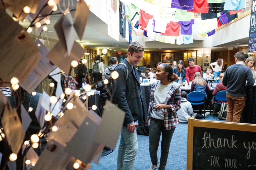 Maria Ahmed speaks with another student at the Holiday Helpers event
