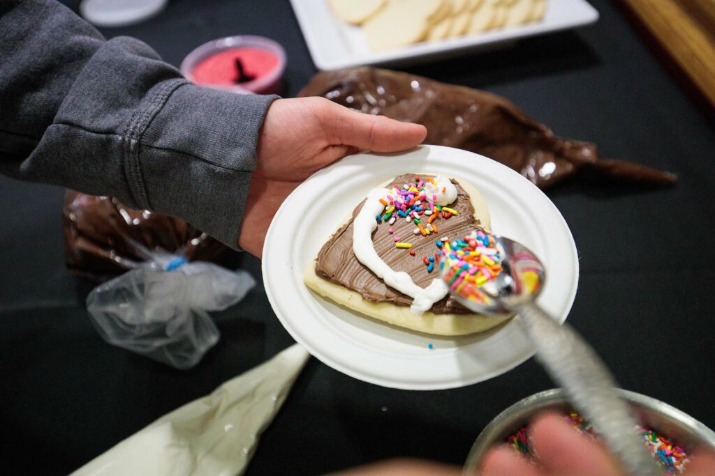 Student decorates cookie at event